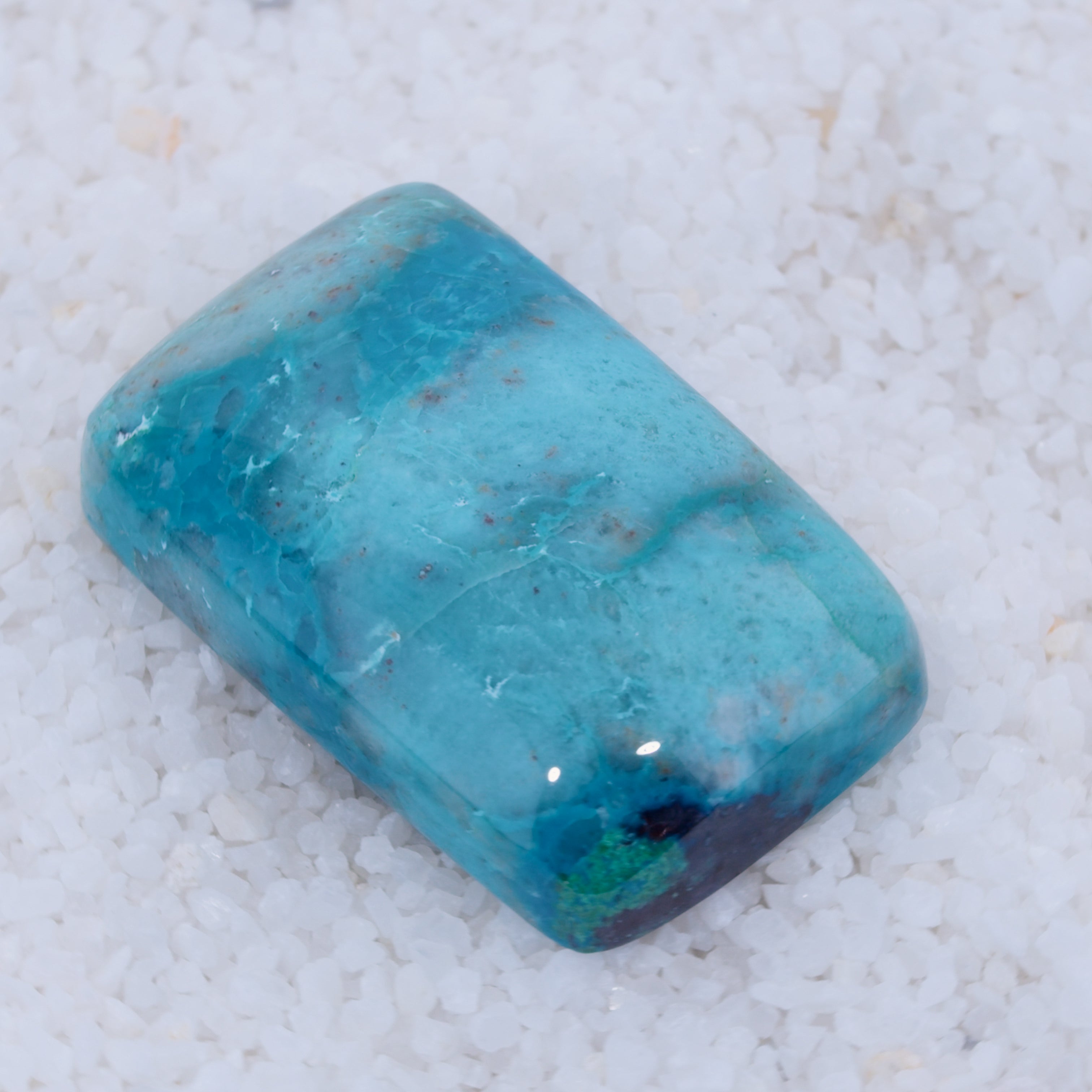 Rectangular blue stone on a white sandy background