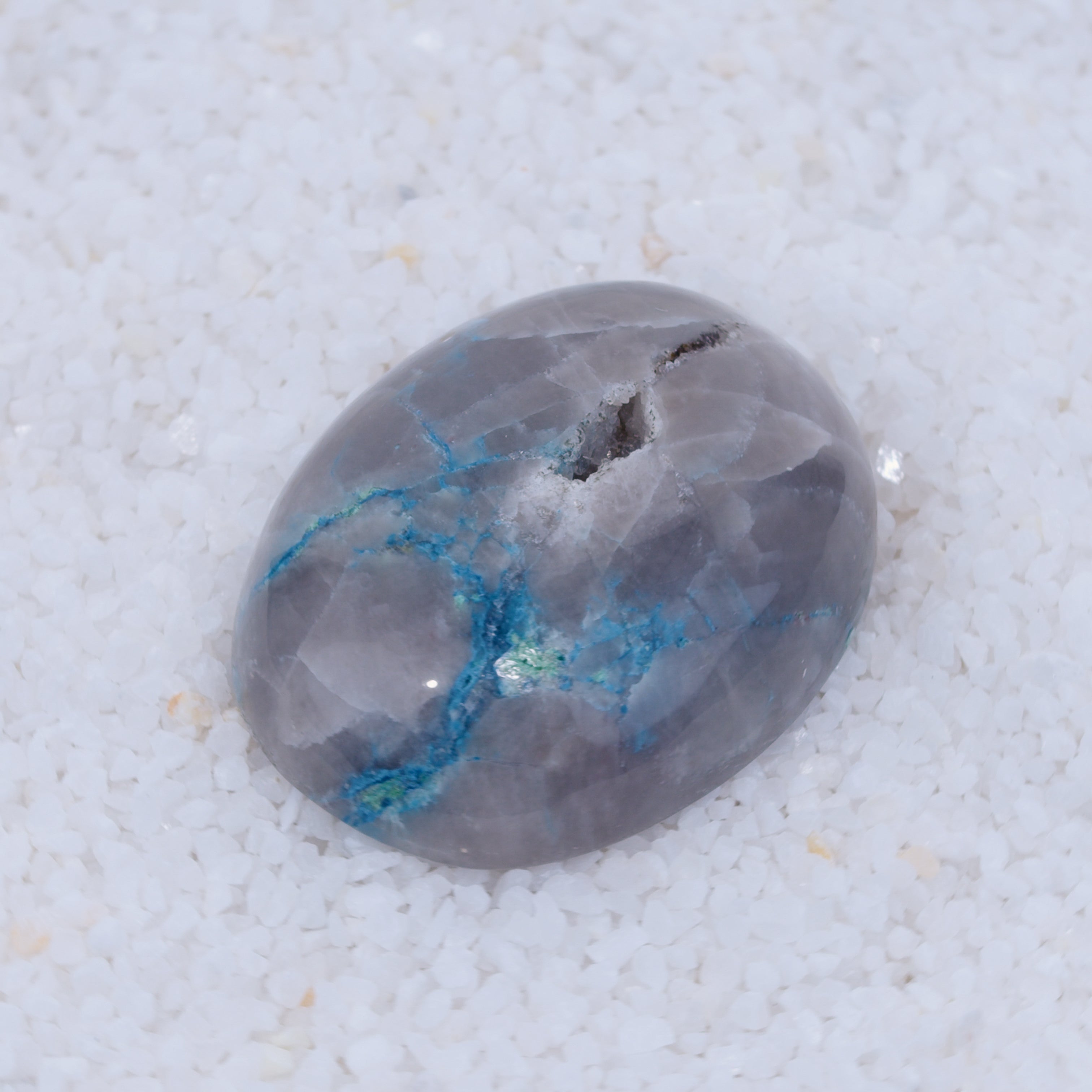 Polished Canyonite stone with blue veins on a white background