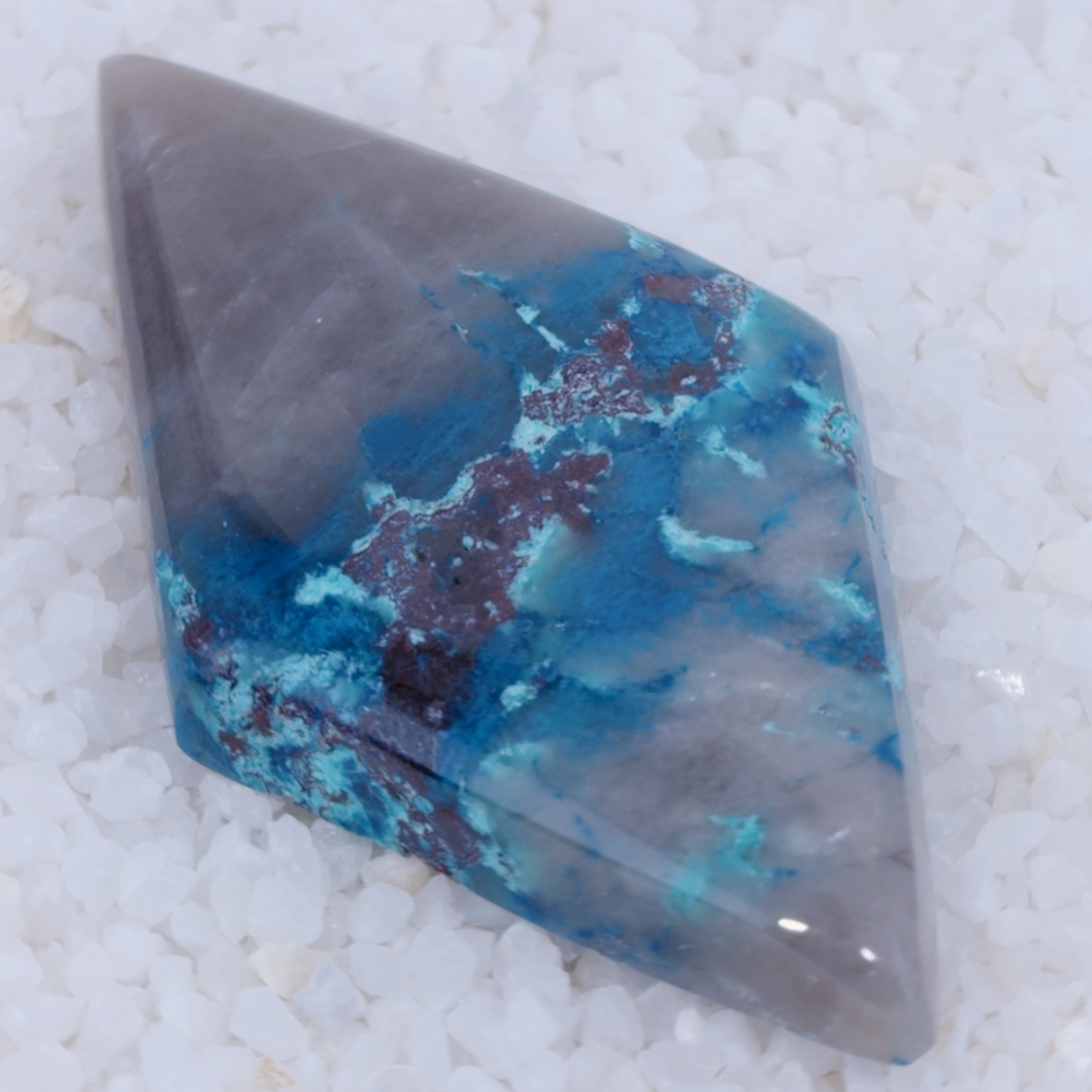 Geometric Canyonite crystal with blue and purple patterns on a white background