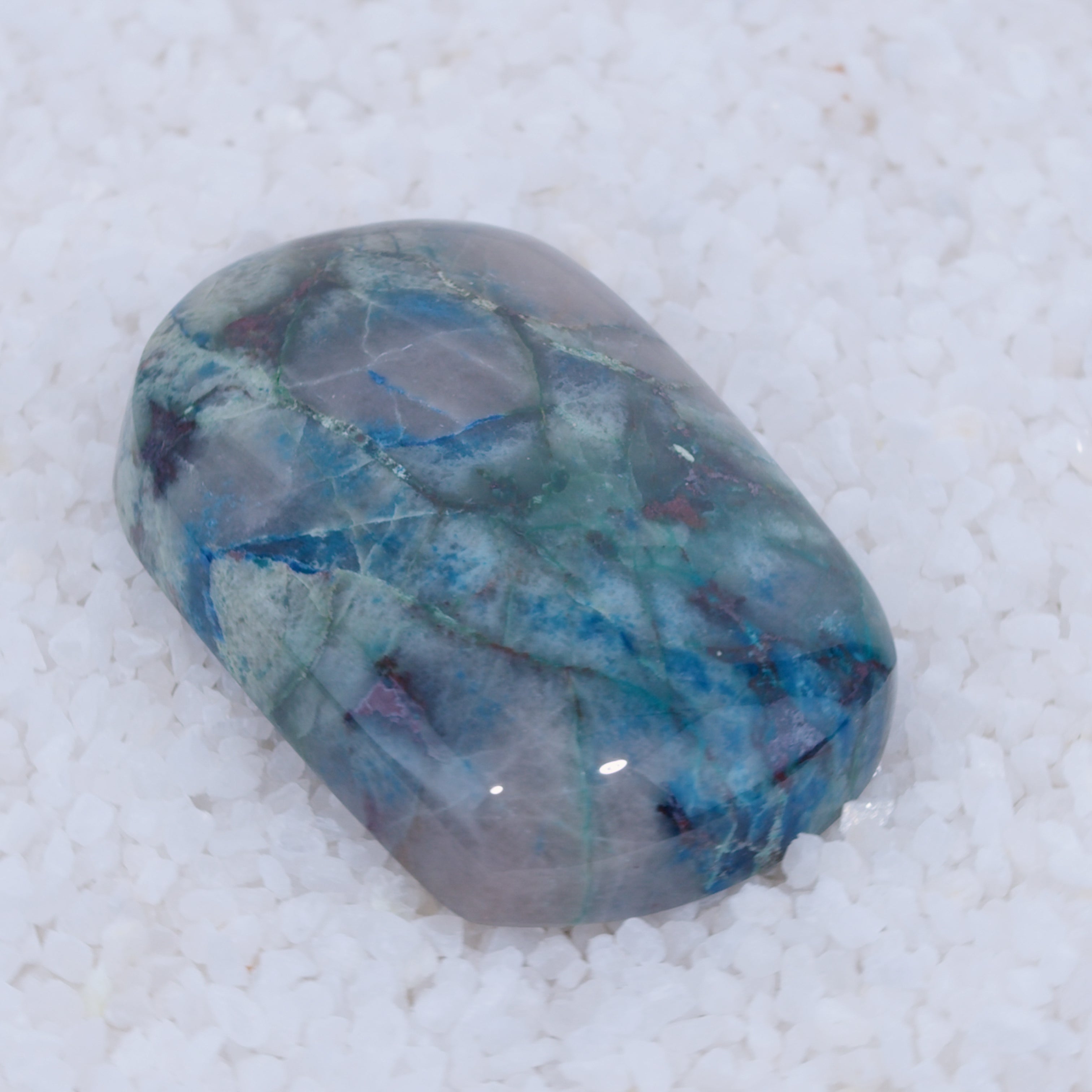 Polished Canyonite gemstone with blue and green patterns on a white background