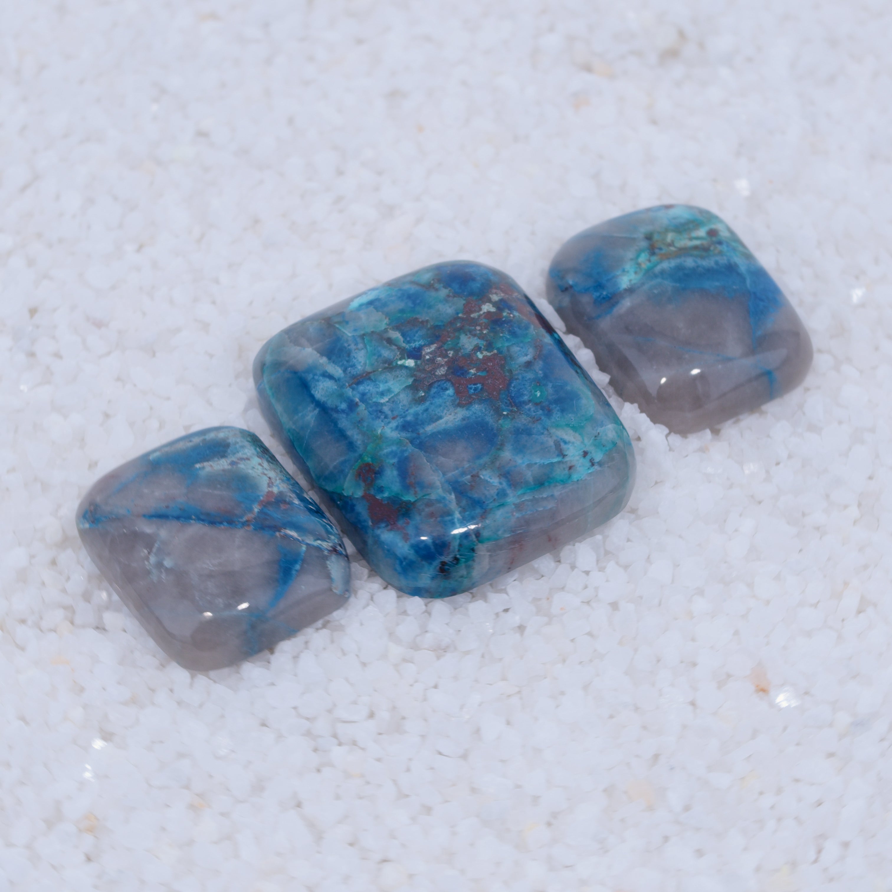 Three blue and gray Canyonite stones on a white background