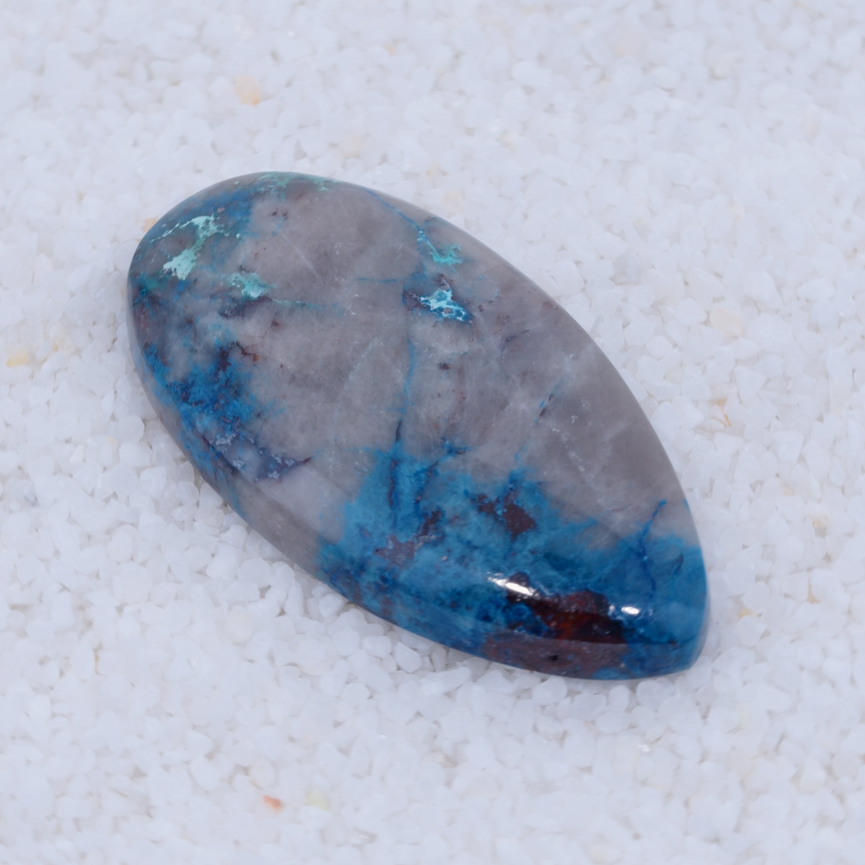 Polished Canyonite gemstone with blue and gray patterns on a white background