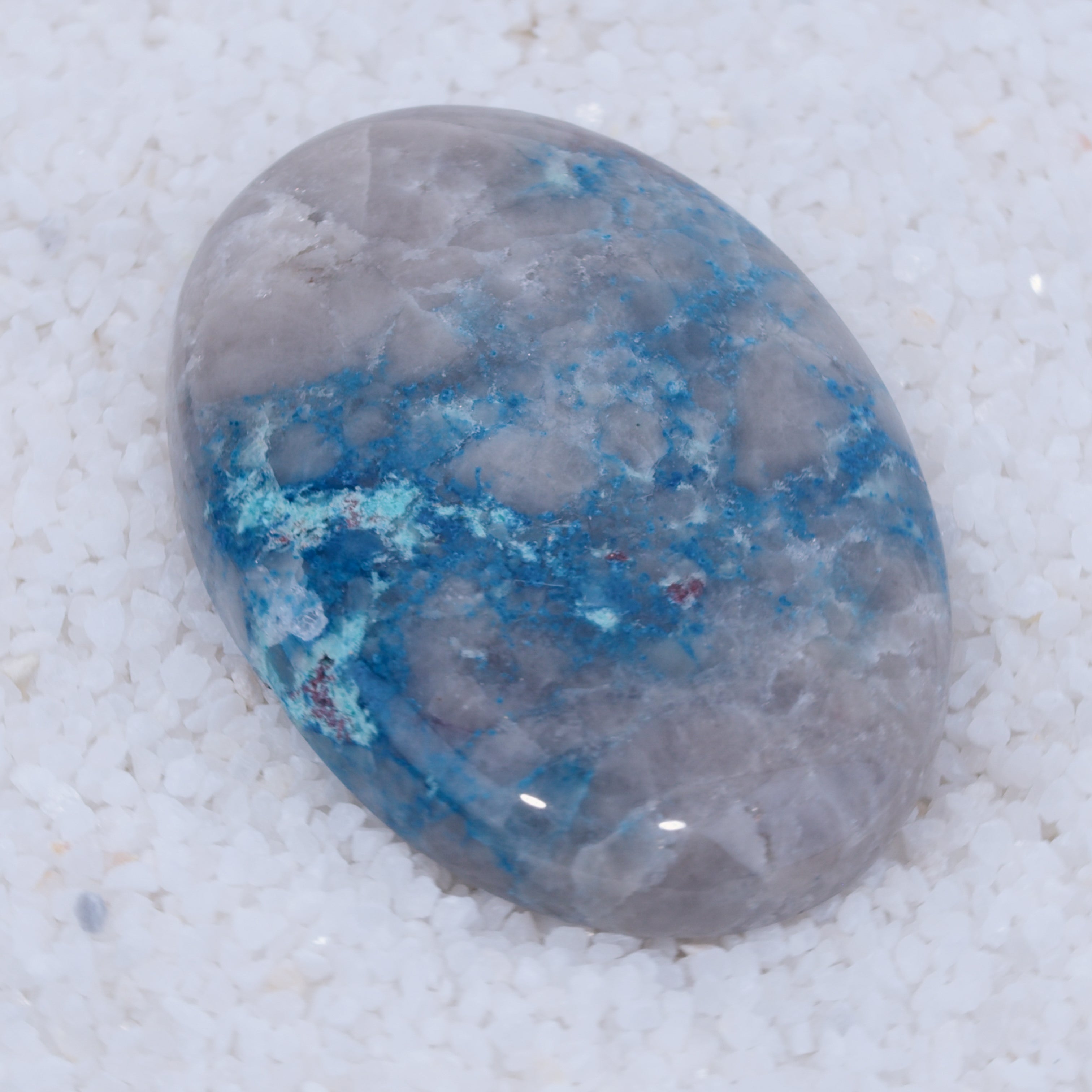Oval-shaped stone with blue and gray colors on a white background