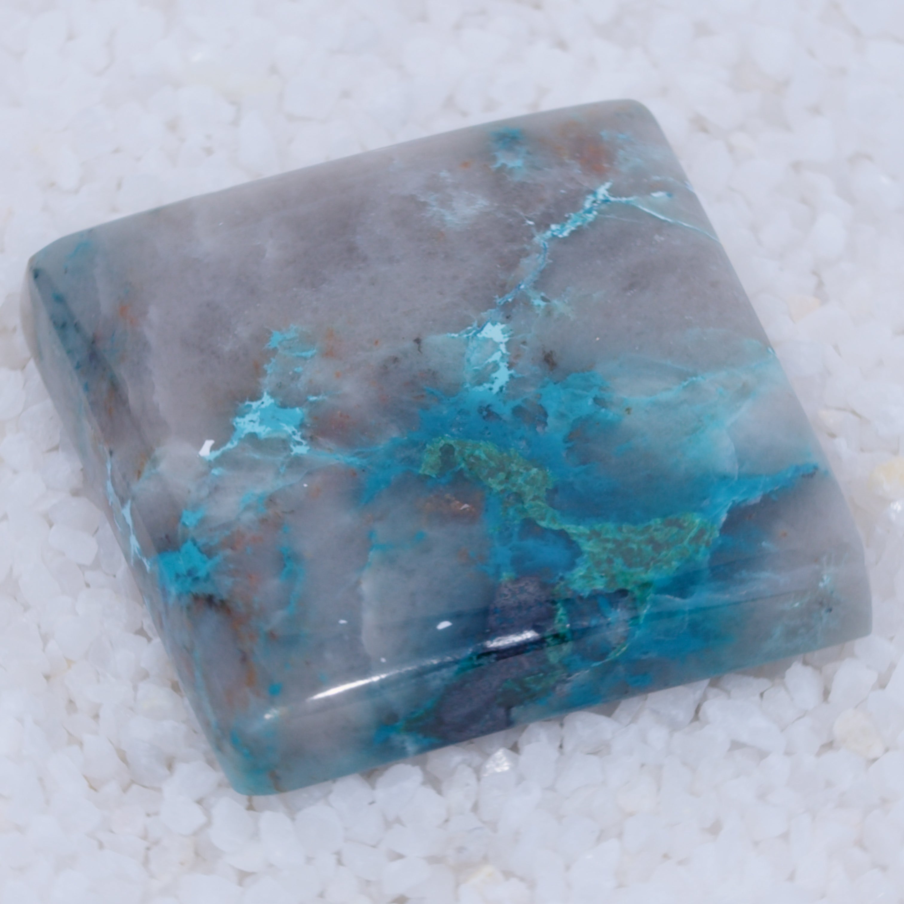 Polished stone with blue and gray coloration on a white background