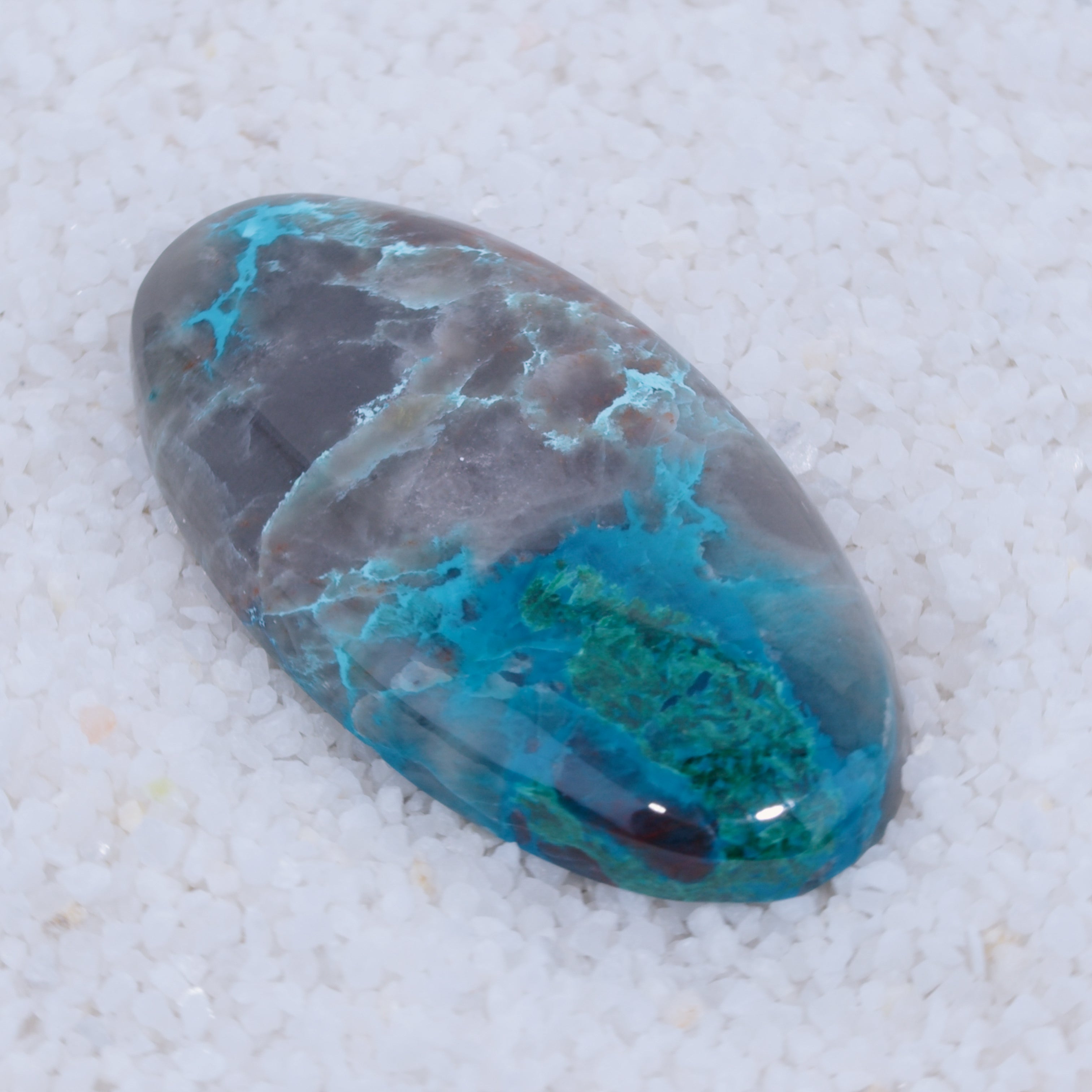 Oval-shaped stone with blue and gray patterns on a white background