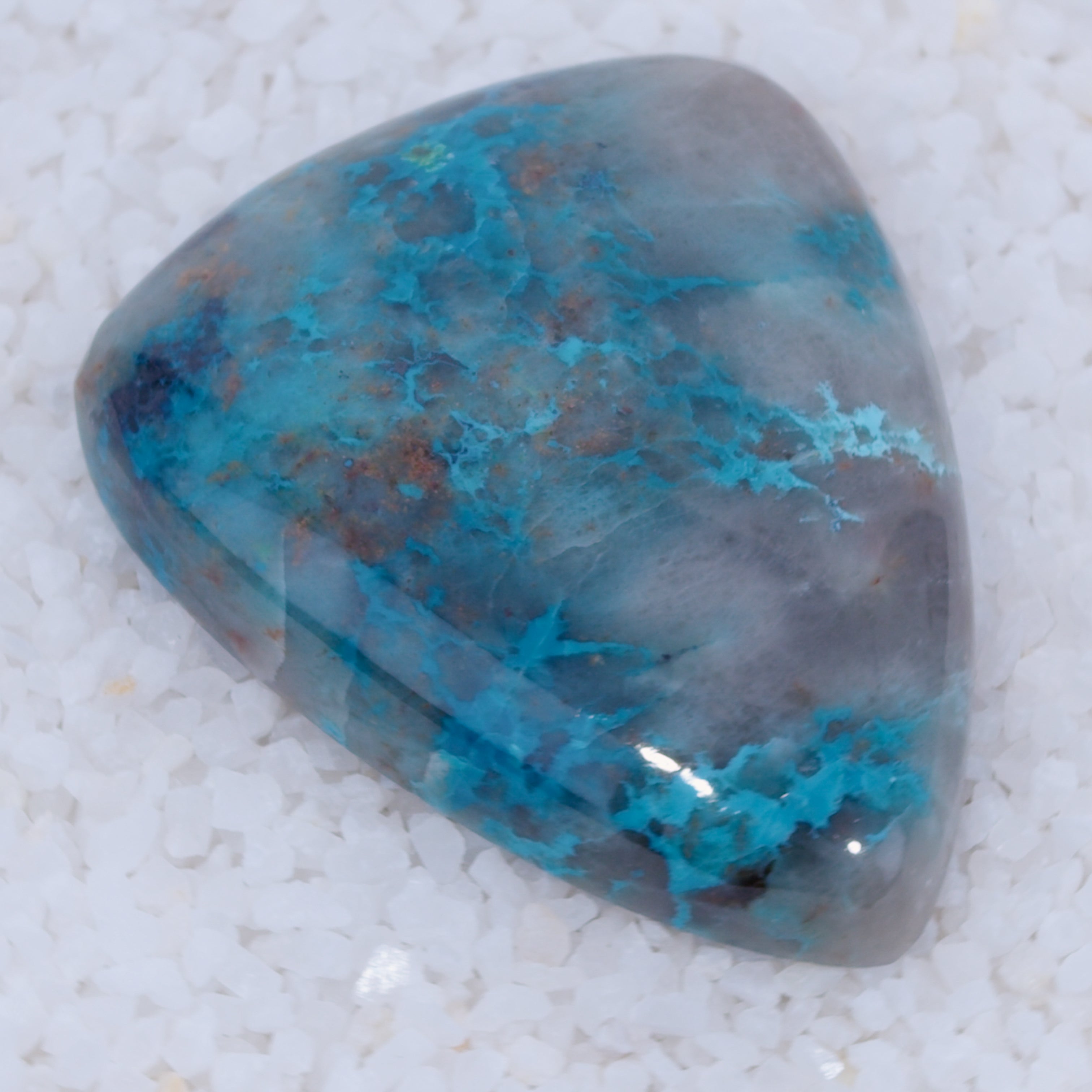 Polished stone with blue and gray coloration on a white background