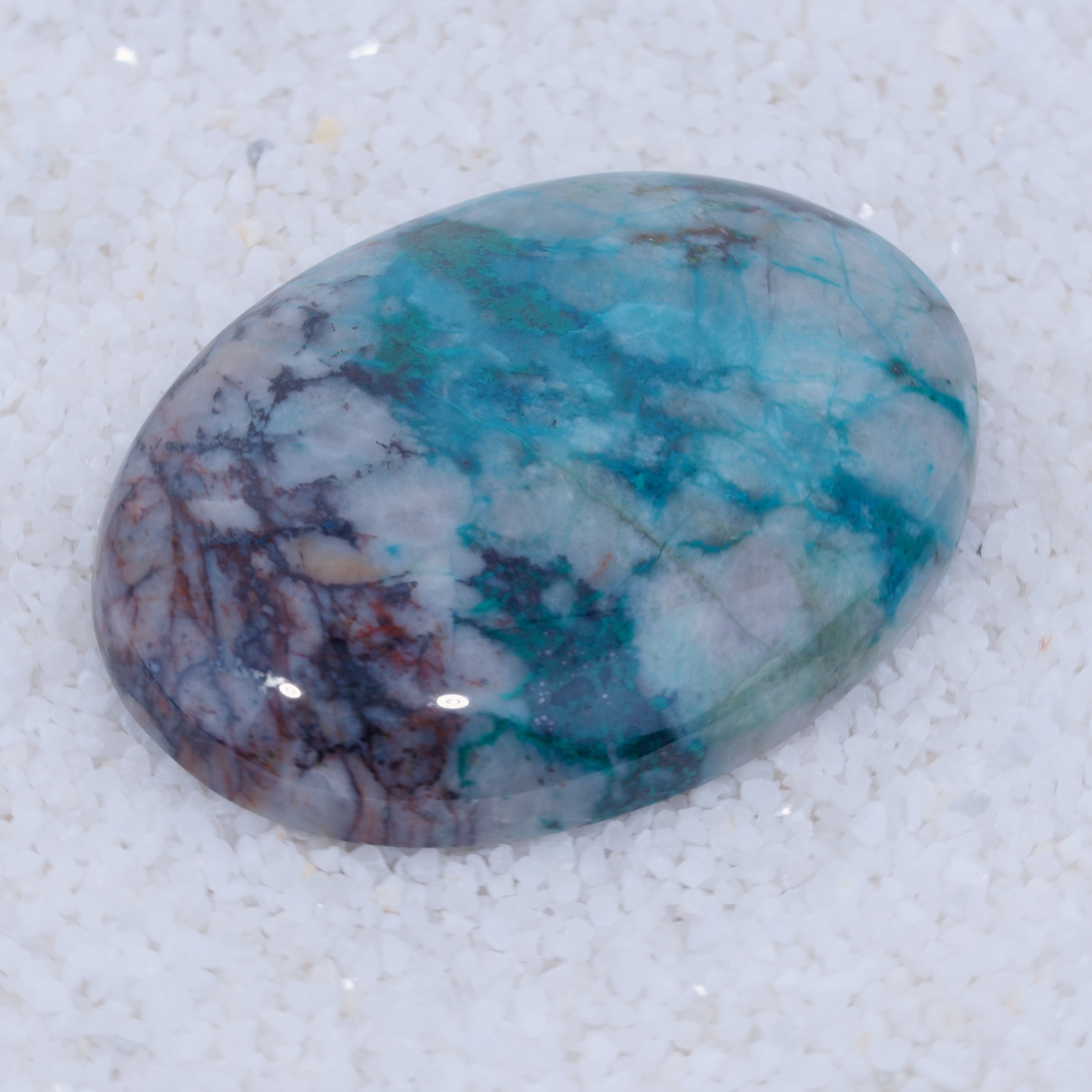 Turquoise stone with purple and white patterns on a white background