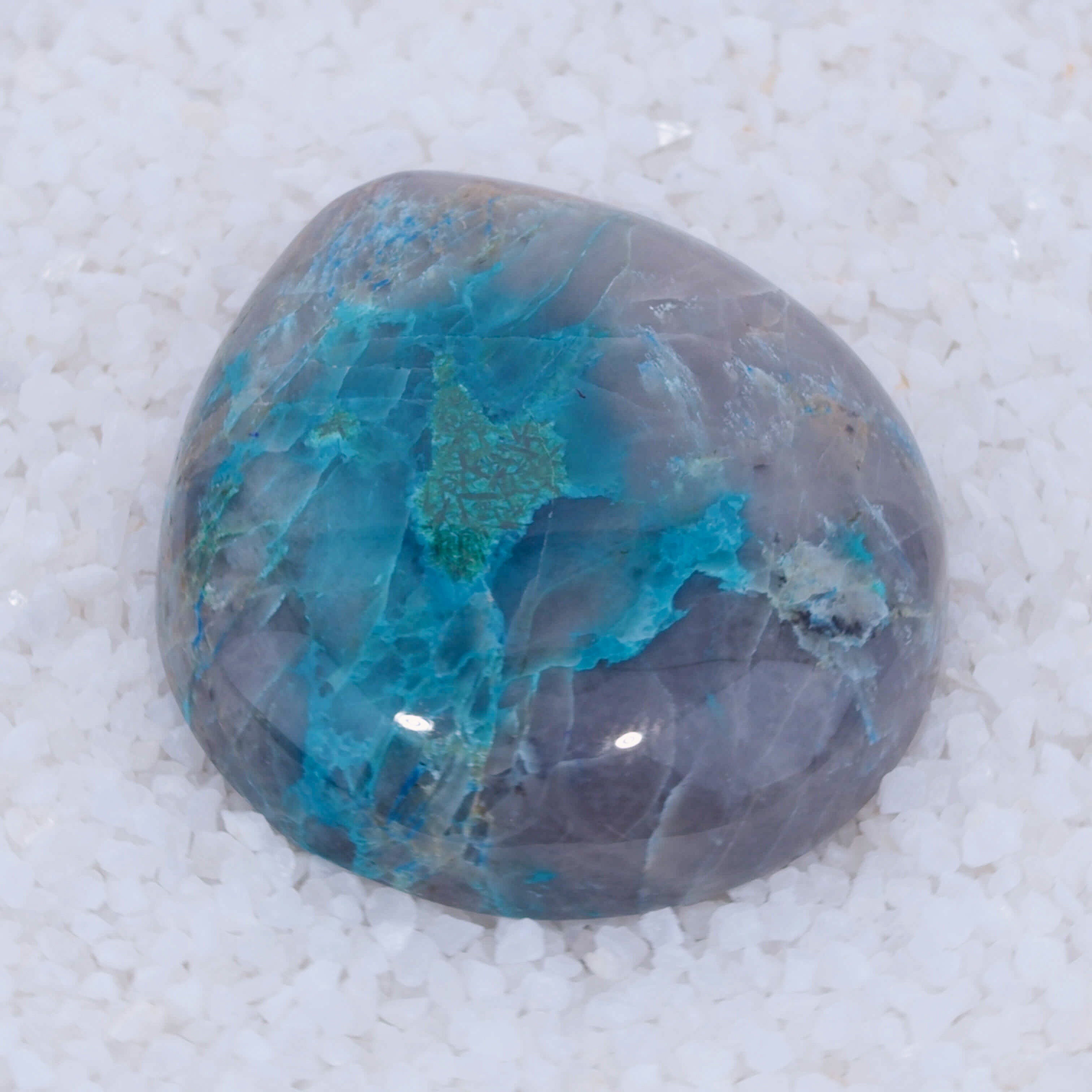 Polished Canyonite gemstone with blue and green patterns on a white background