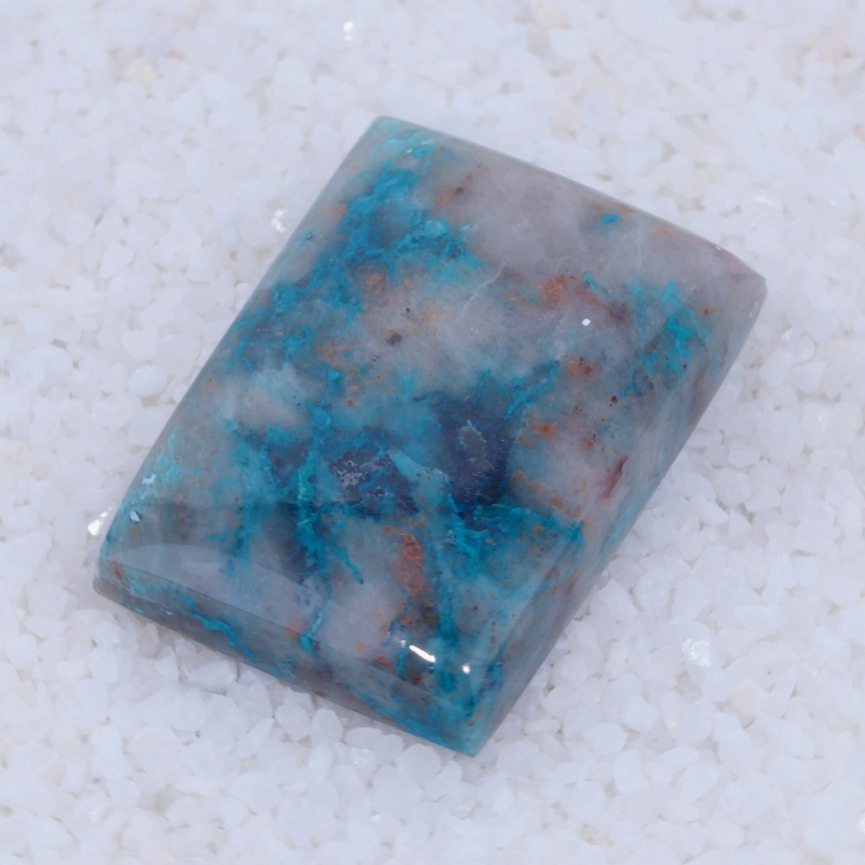 Polished Canyonite stone with blue and gray patterns on a white background