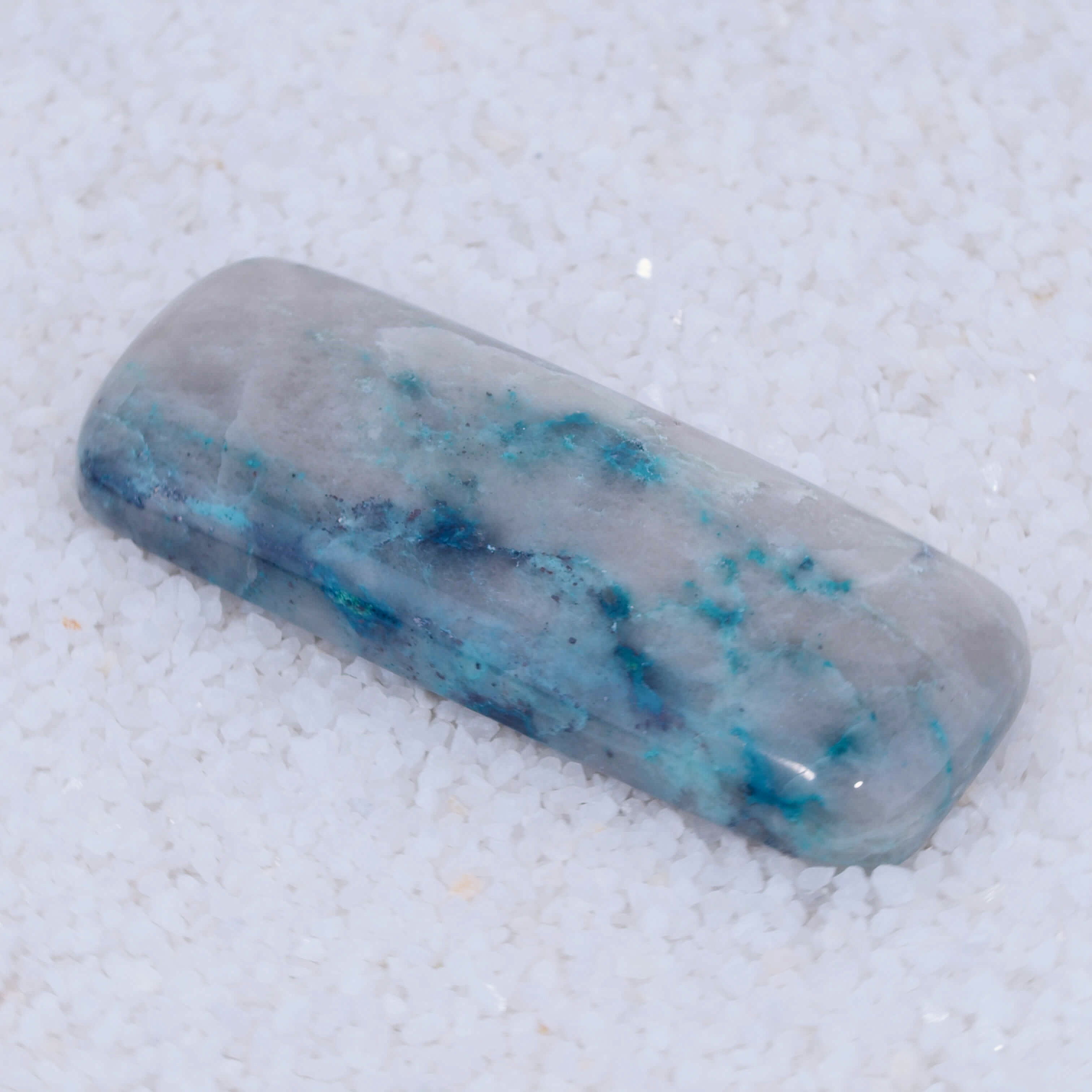 Crystal Canyonite with blue and white patterns on a textured white background