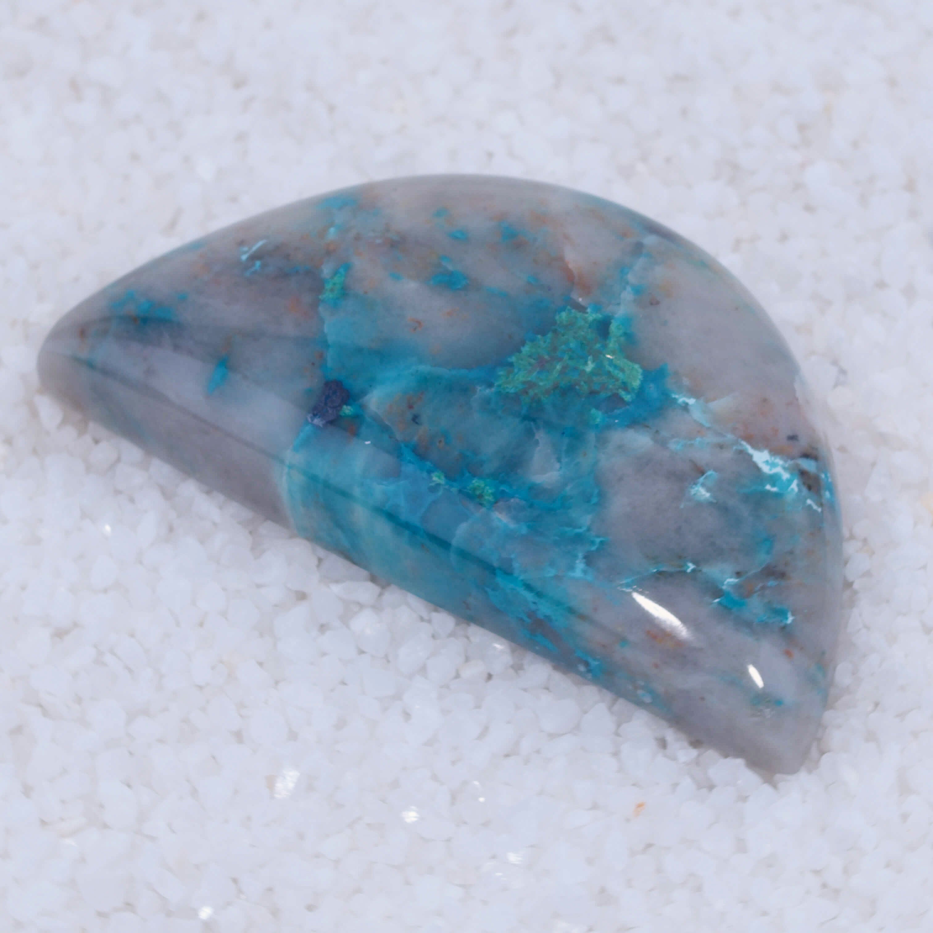 Teardrop-shaped Canyonite stone with blue and gray colors on a white background