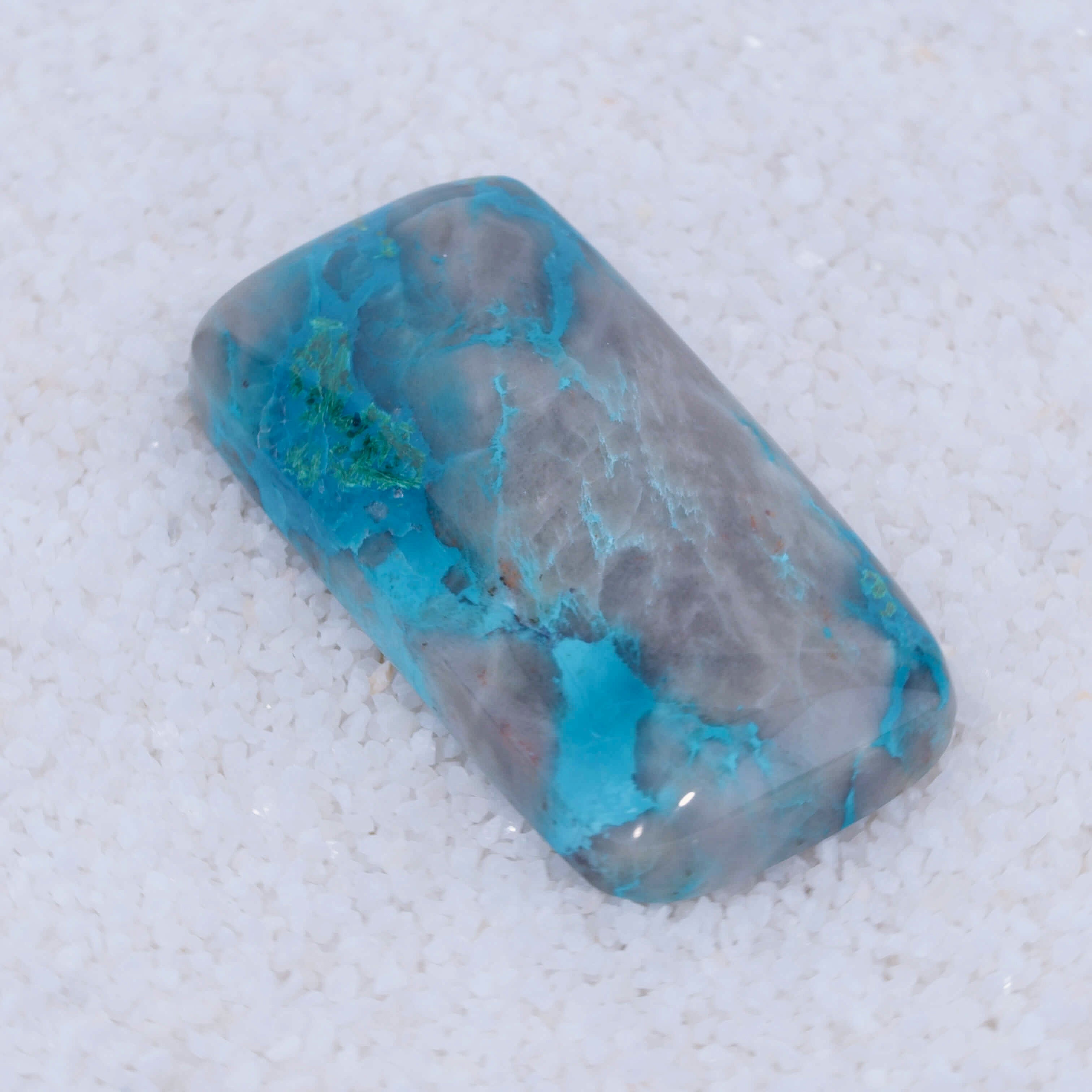 Turquoise colored Canyonite stone on a white background