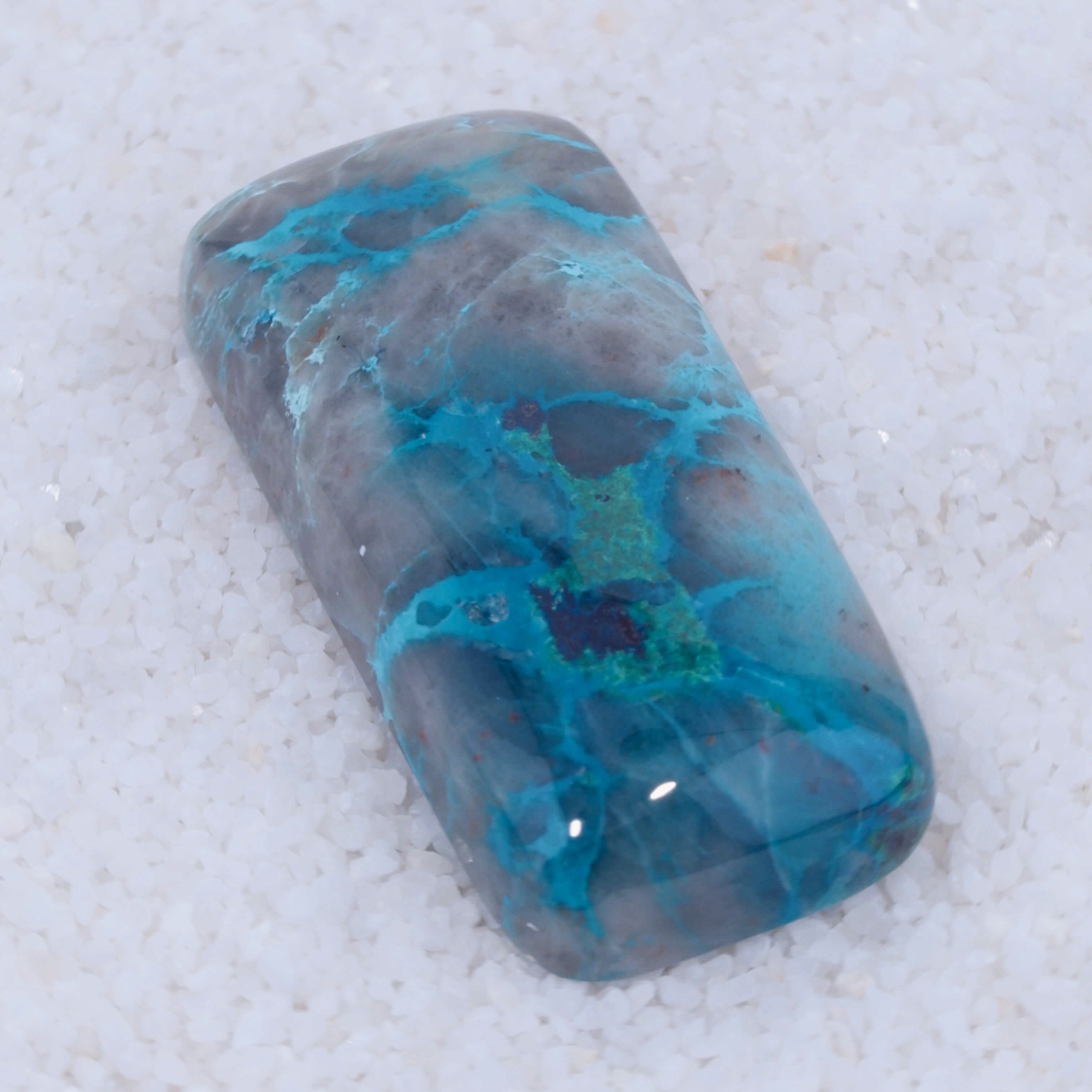 Turquoise colored Canyonite stone with blue and green patterns on a white background