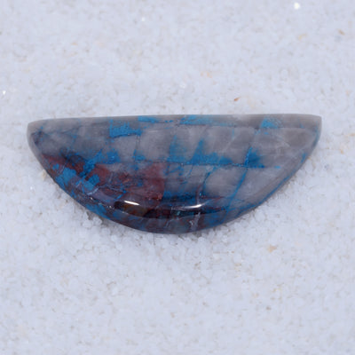 Half-shaped stone with blue and red patterns on a white background
