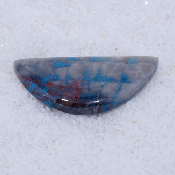 Half-shaped stone with blue and red patterns on a white background