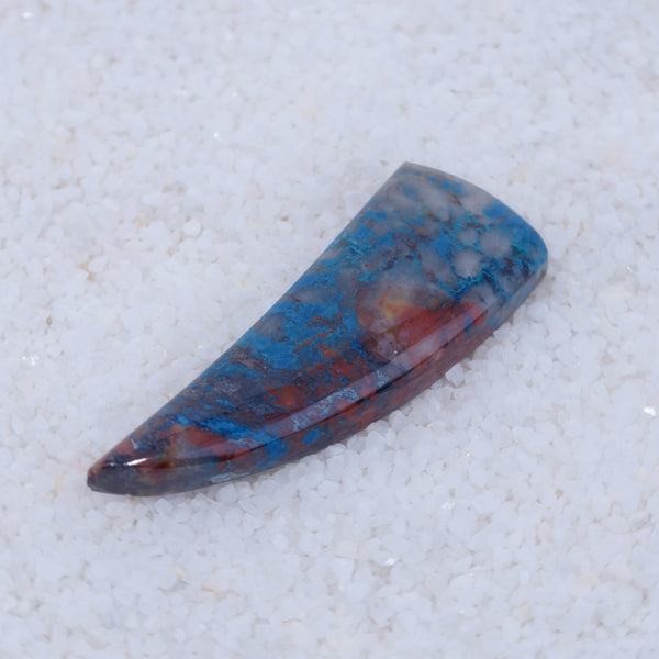 Polished Canyonite stone with blue and red patterns on a light gray background