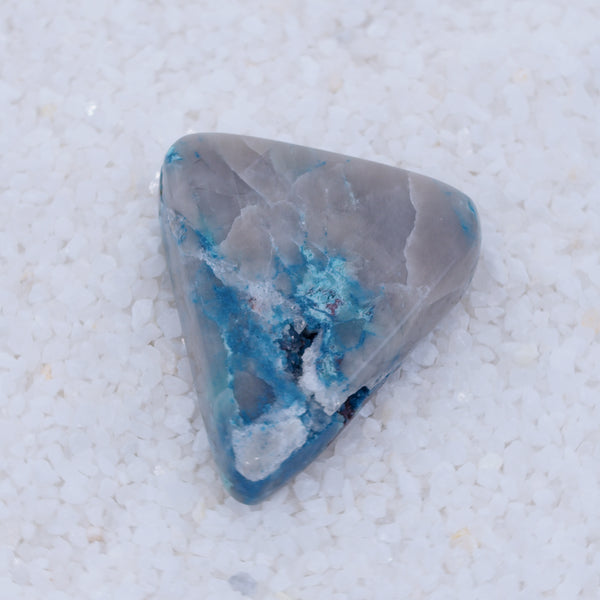 Triangular stone with blue and gray patterns on a white background