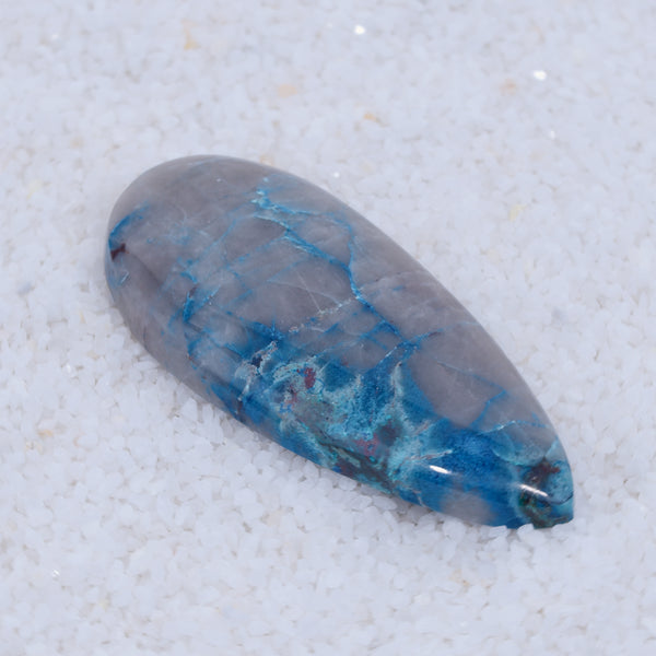 Blue and gray Canyonite stone on a textured white background