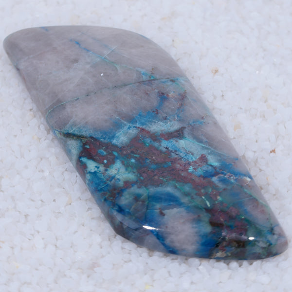 Polished Canyonite stone with blue and purple patterns on a white background