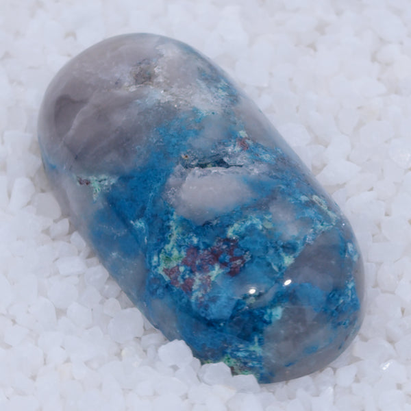 Blue and gray crystal Canyonite on a white sandy background