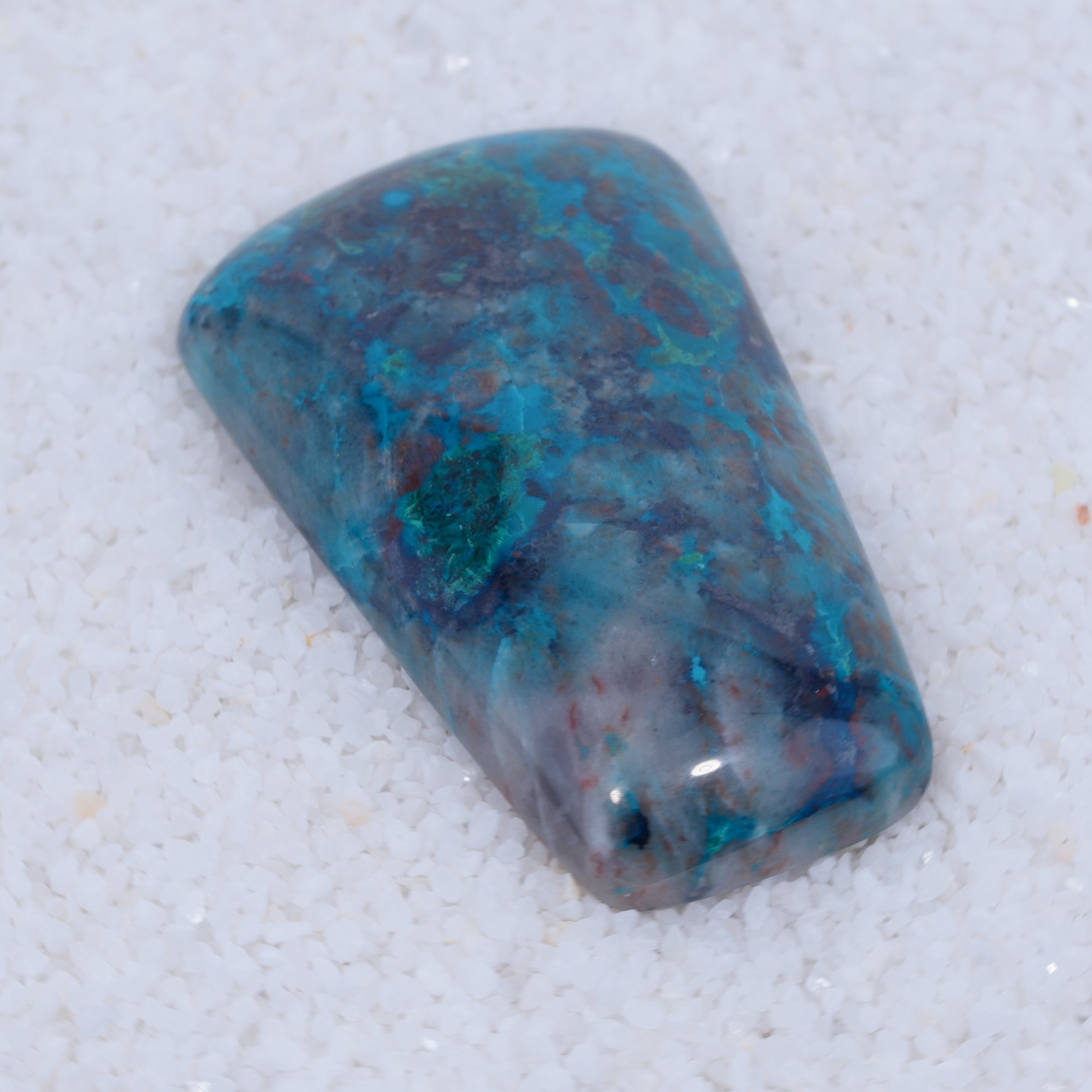 Polished Canyonite blue and purple stone on a light gray background