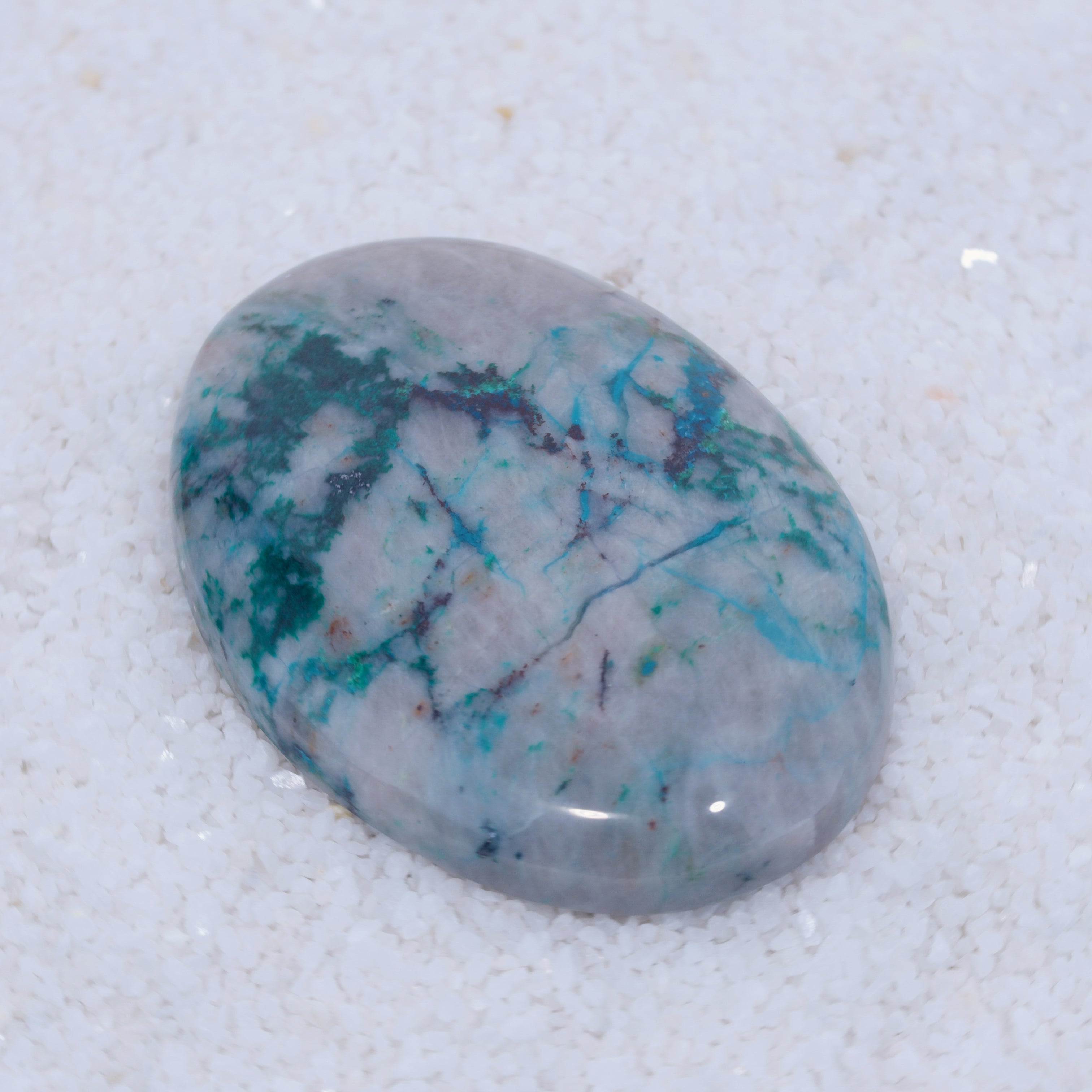 Polished Canyonite gemstone with blue and green patterns on a white background