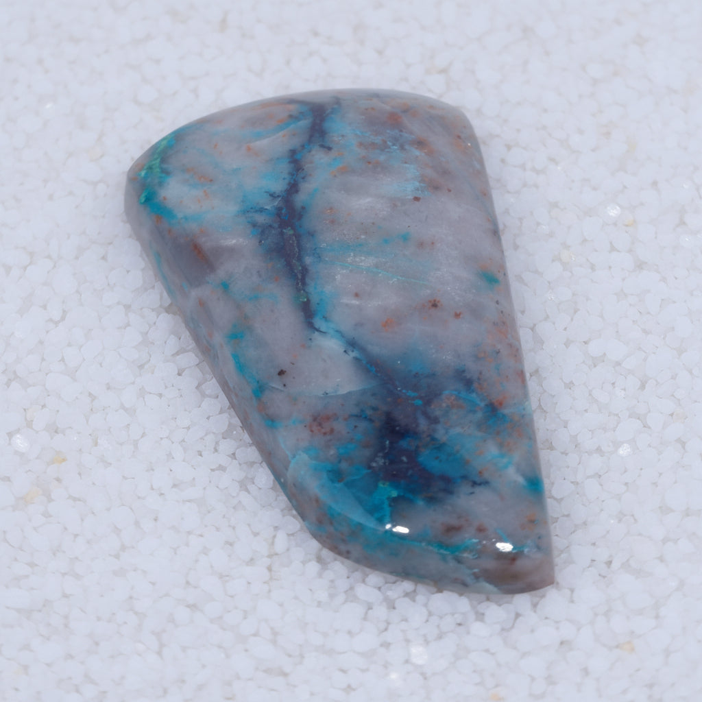 Polished stone with blue and red patterns on a white background