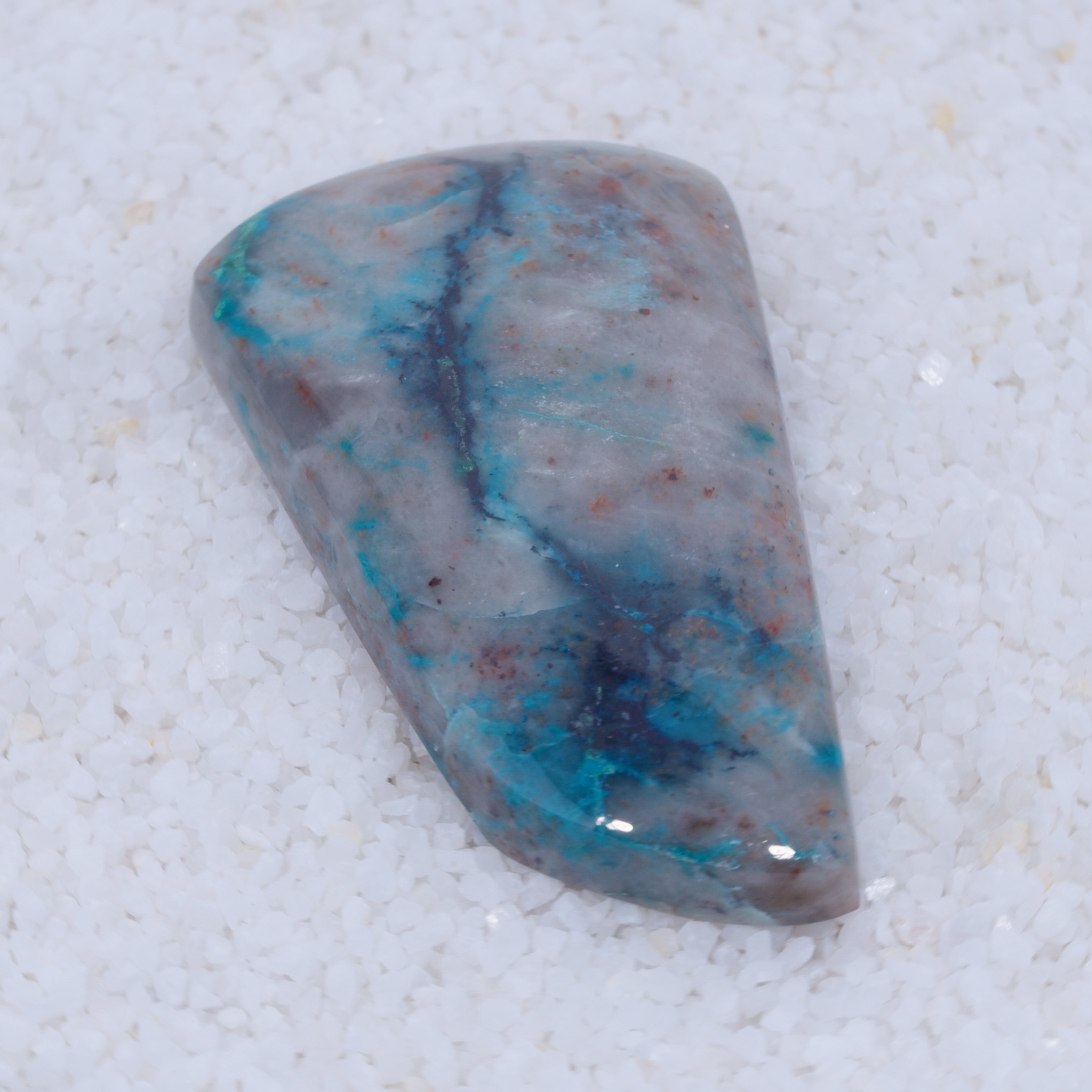 Polished stone with blue and red patterns on a white background