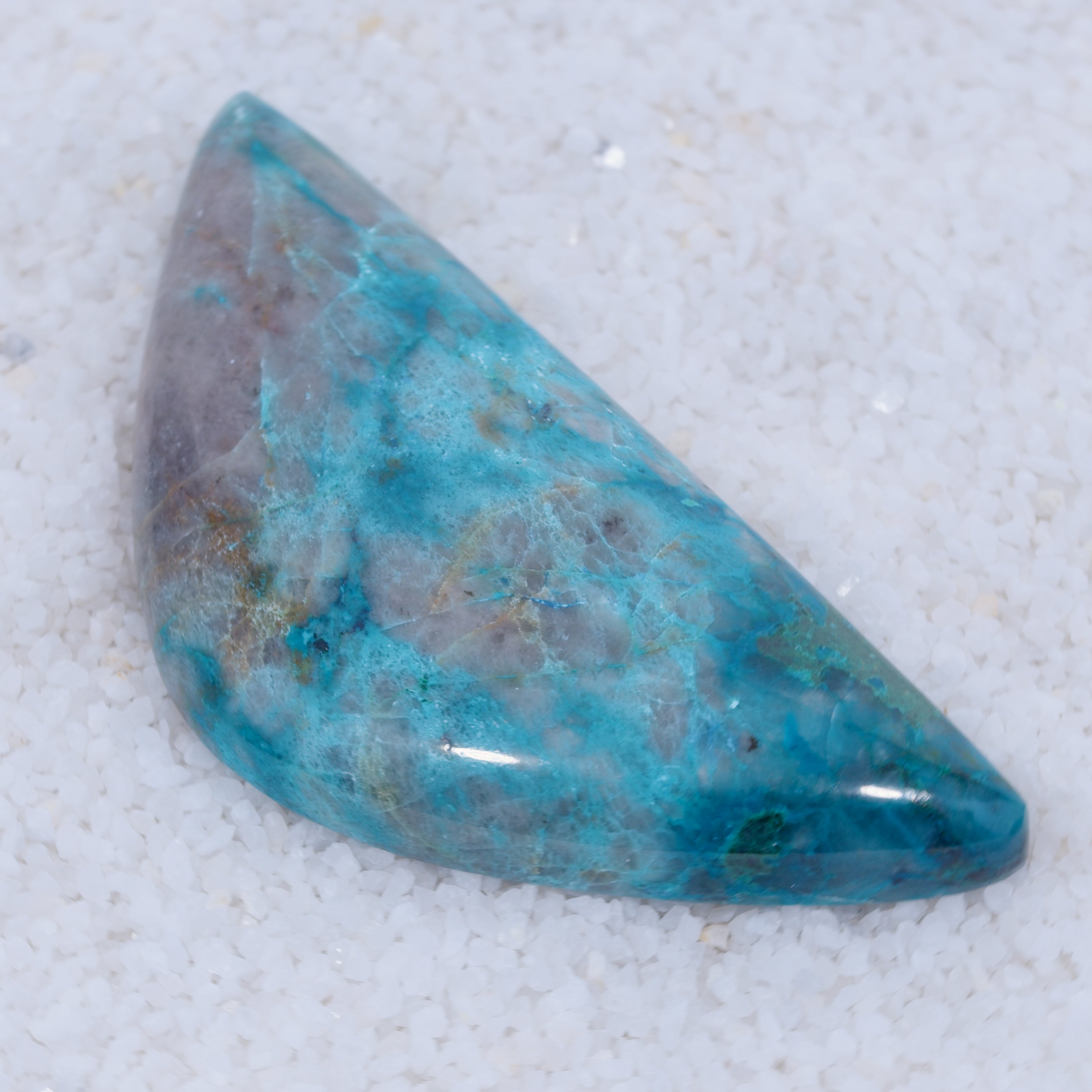 Teardrop-shaped Canyonite turquoise colored stone on a light gray background
