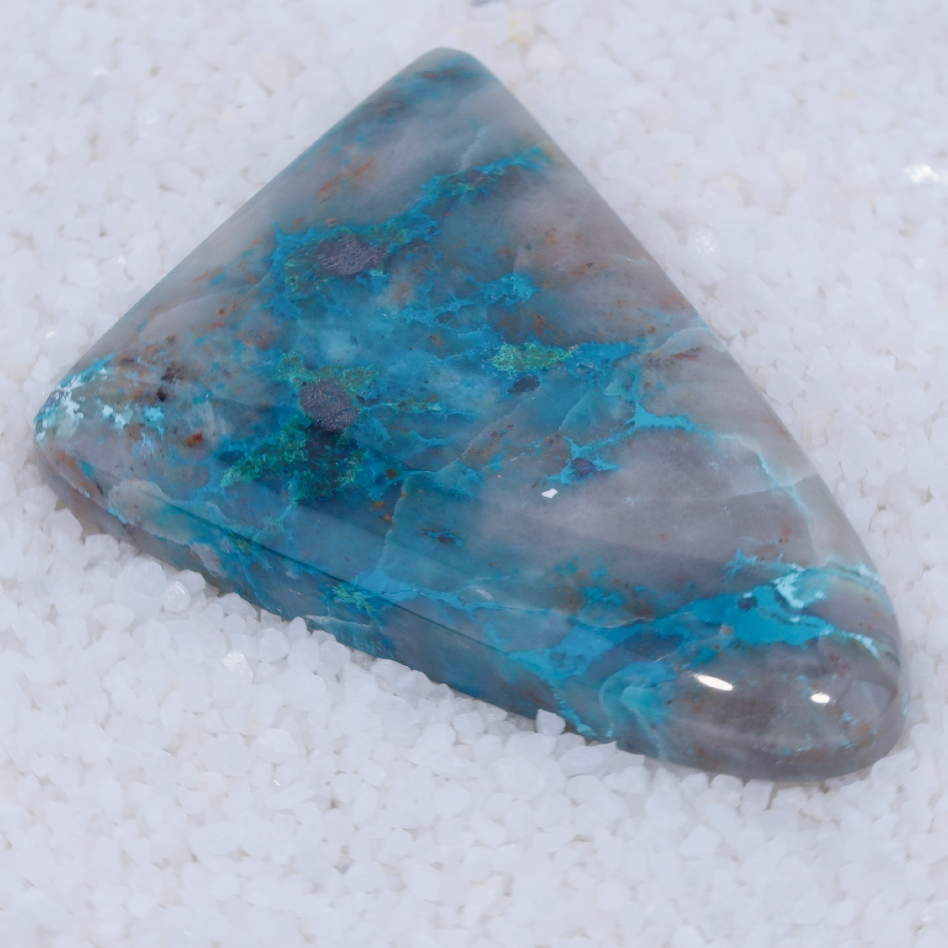 Triangular Canyonite stone with blue and gray patterns on a white background