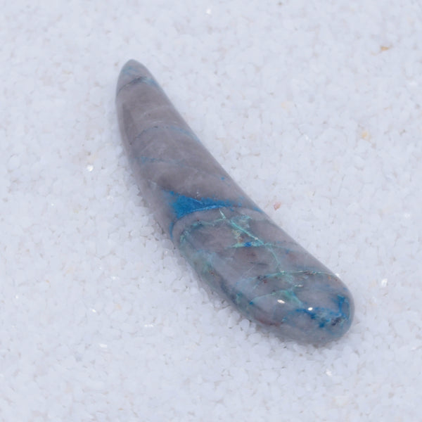 Tapered stone with blue inclusions on a white background