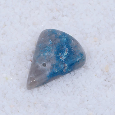 Blue and gray teardrop-shaped stone on a light gray background