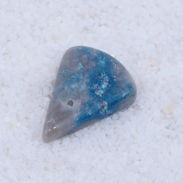 Blue and gray teardrop-shaped stone on a light gray background