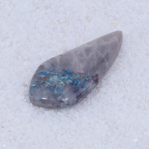 Trapezoidal Canyonite crystal with blue inclusions on a white background