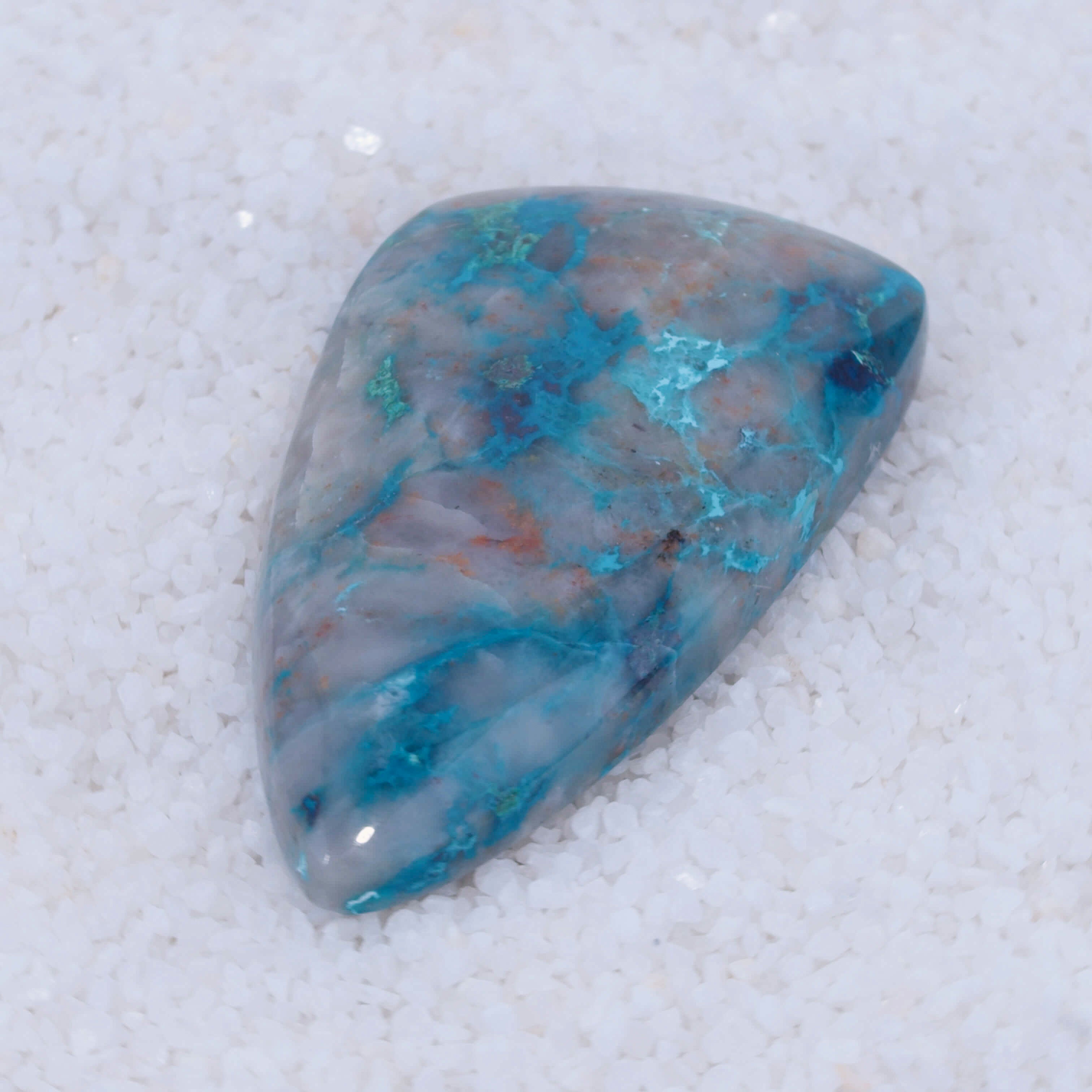Turquoise colored Canyonite stone with blue and gray patterns on a white background