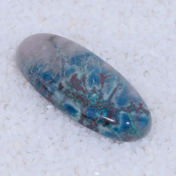 Marbled Canyonite stone with blue, green, and red patterns on a white background