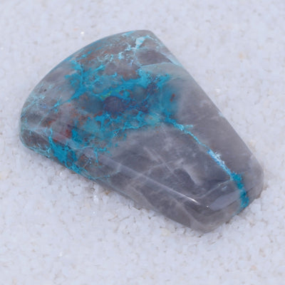Turquoise colored Canyonite stone with blue and gray patterns on a white background