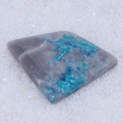 Gray Quartz Canyonite stone with blue veins on a textured white background