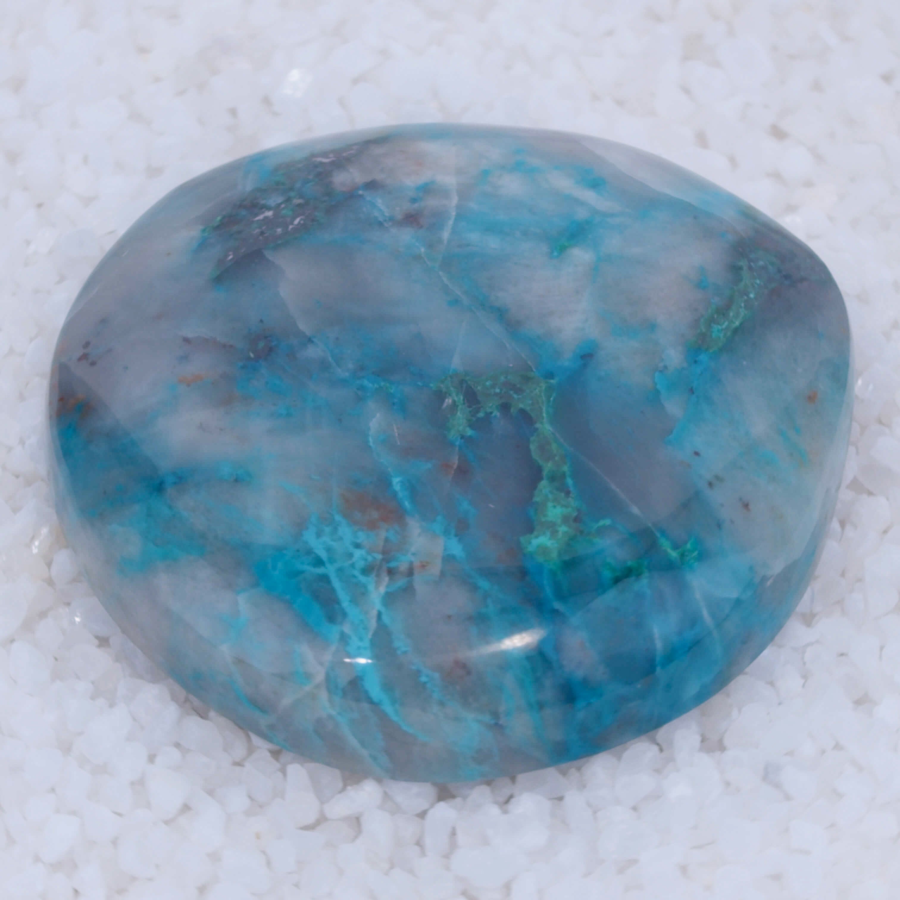 Turquoise colored Canyonite stone with a marbled pattern on a white background