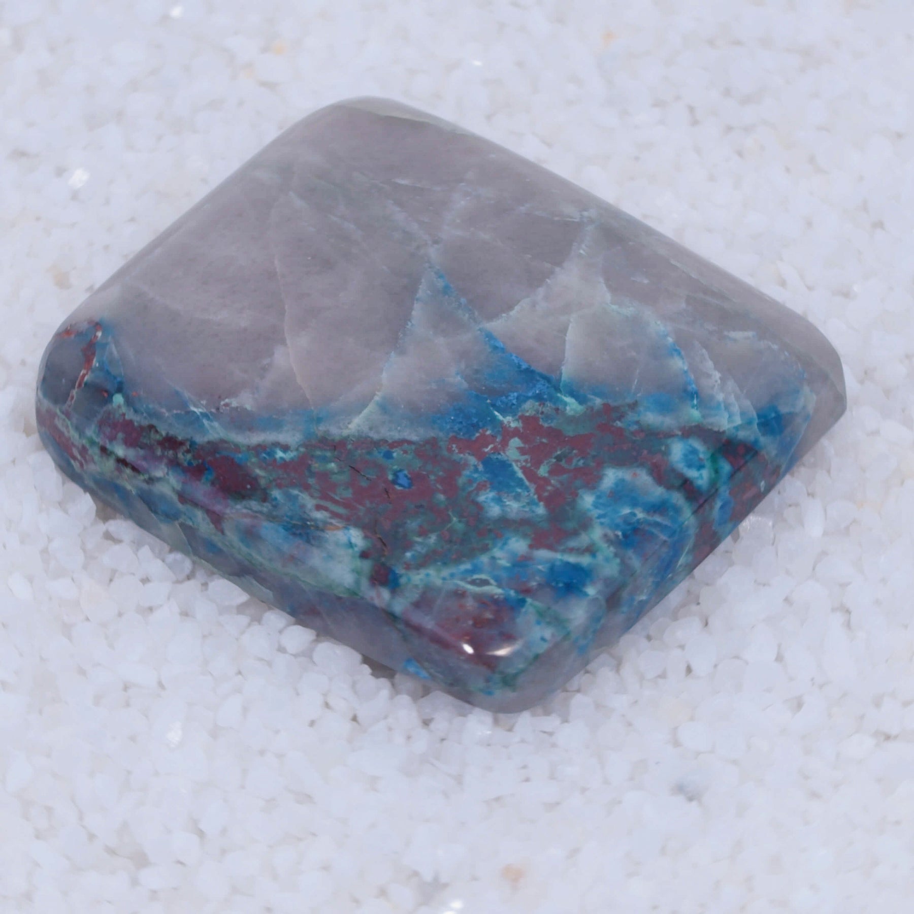 Dark blue Papagoite and copper-silicate inclusions in a polished Canyonite cabochon