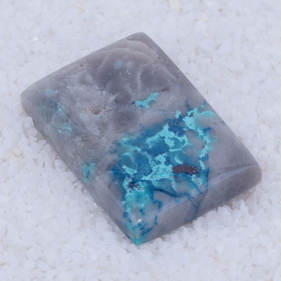 Rectangular Canyonite stone with blue veins on a white background