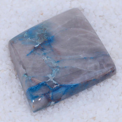 Polished Canyonite stone with blue and gray patterns on a white background