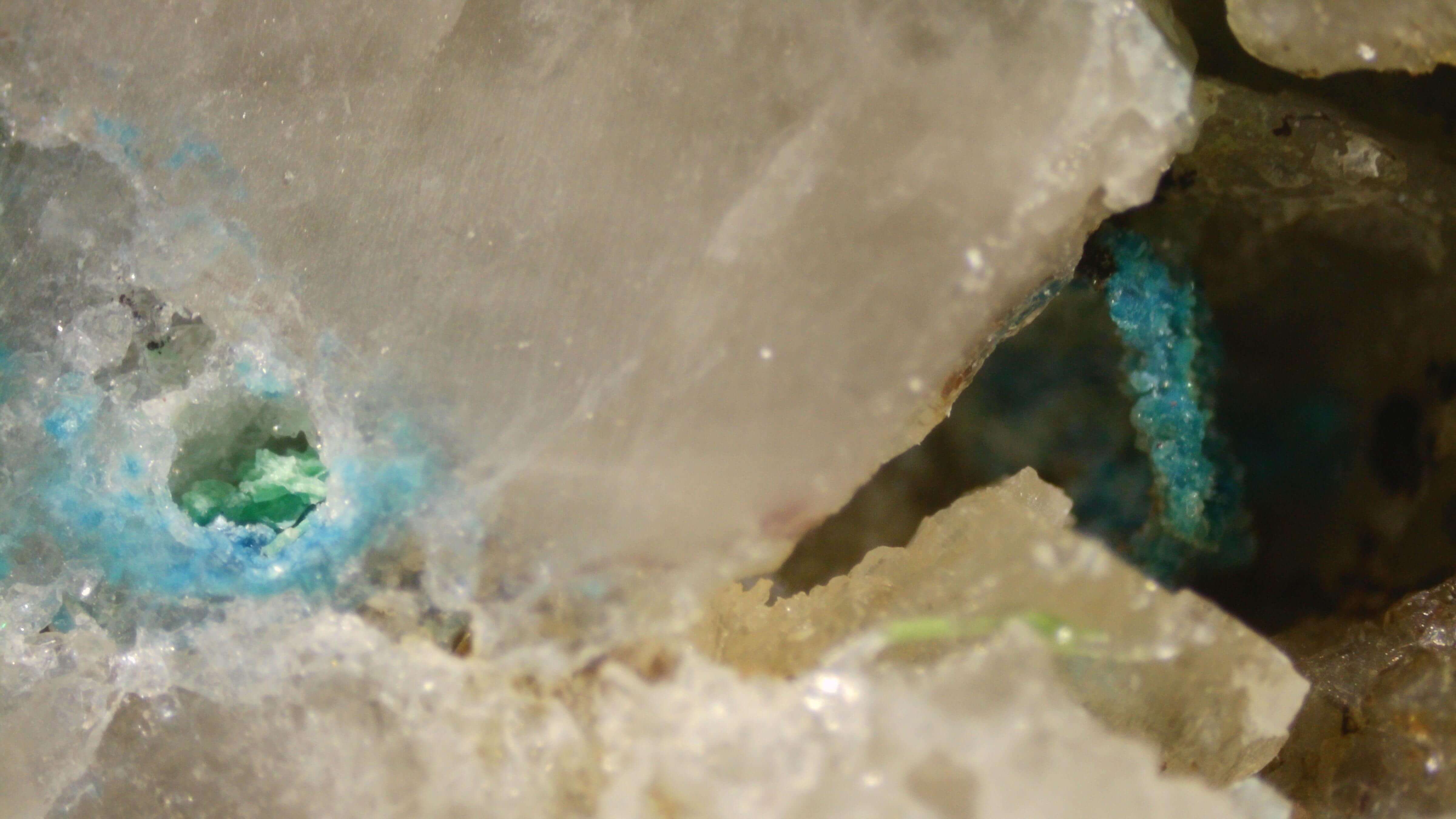 Microscopic translucent silica matrix surrounding blue copper mineralization